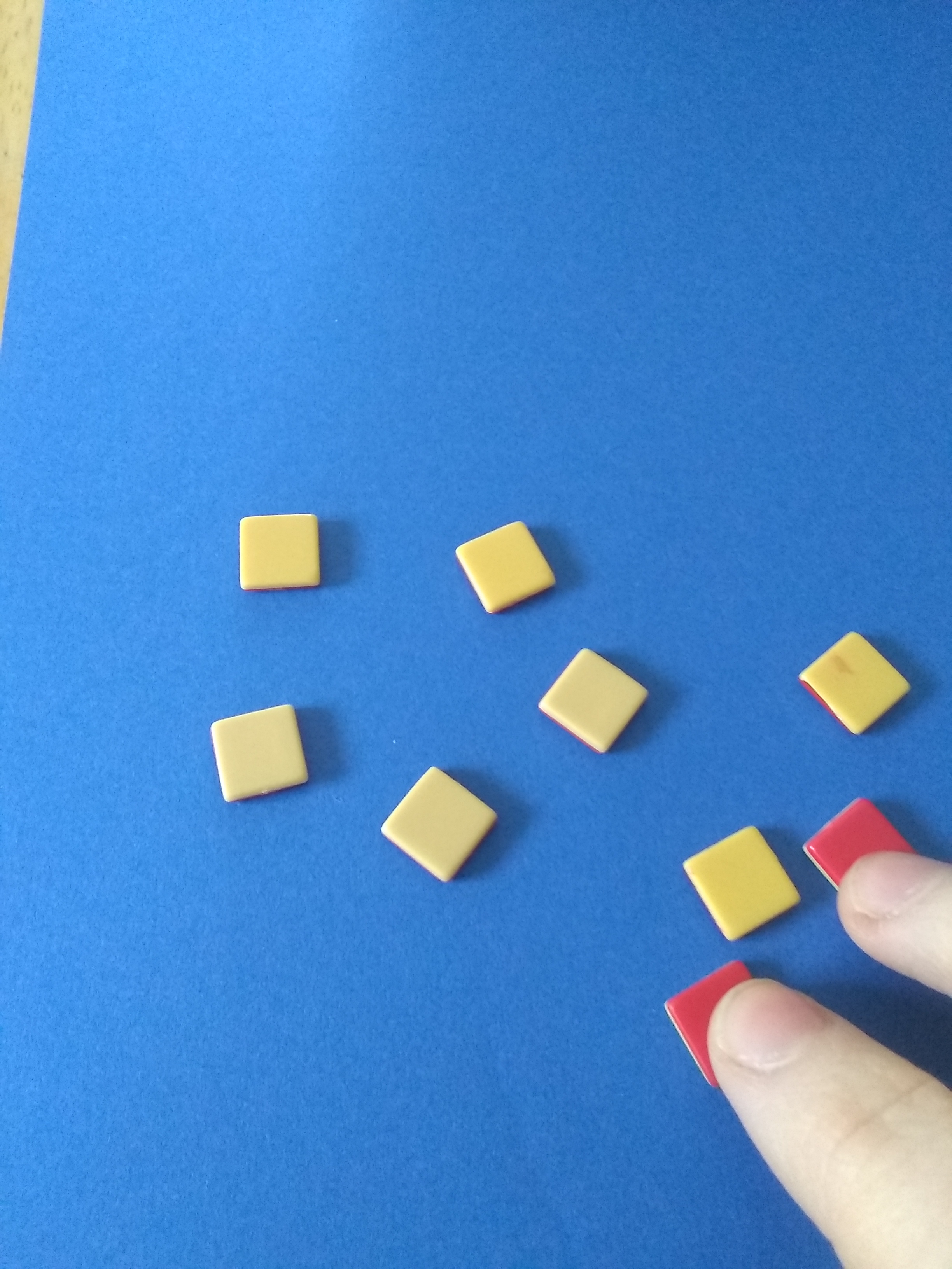fingers pulling away the 2 negative counters leaving 7 positive counters